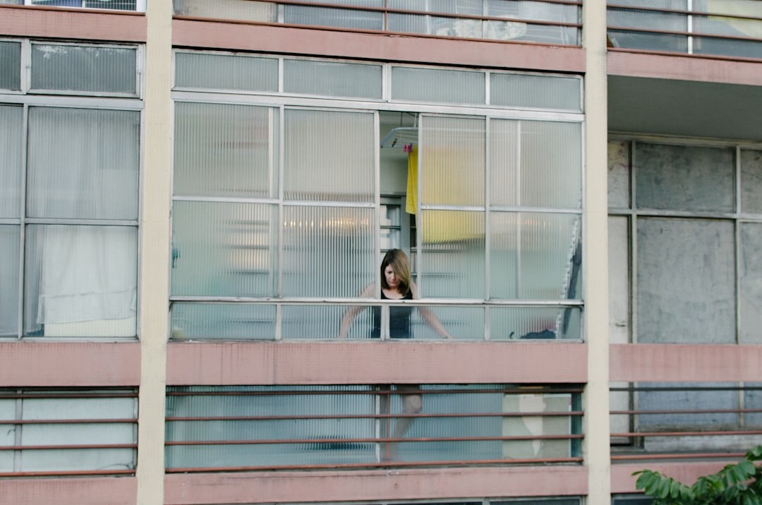 Young Brazilian woman journaling calmly by a window with soft natural light