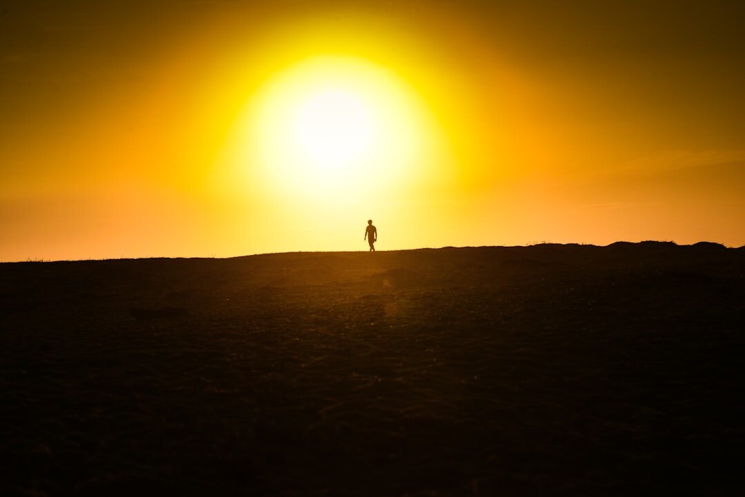 Brazilian woman hiking uphill at sunrise looking toward the horizon
