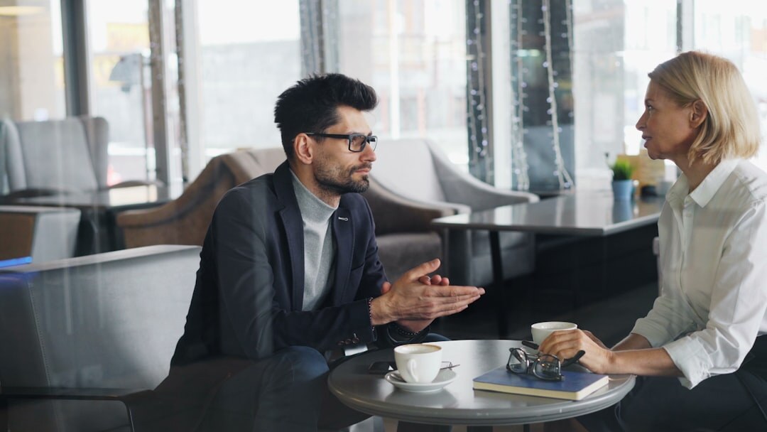 Two Brazilian colleagues having an attentive conversation at a wooden table
